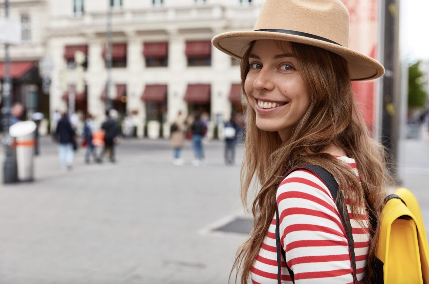 Girl smiling with yellow backpack - Your Italian life, unlocked